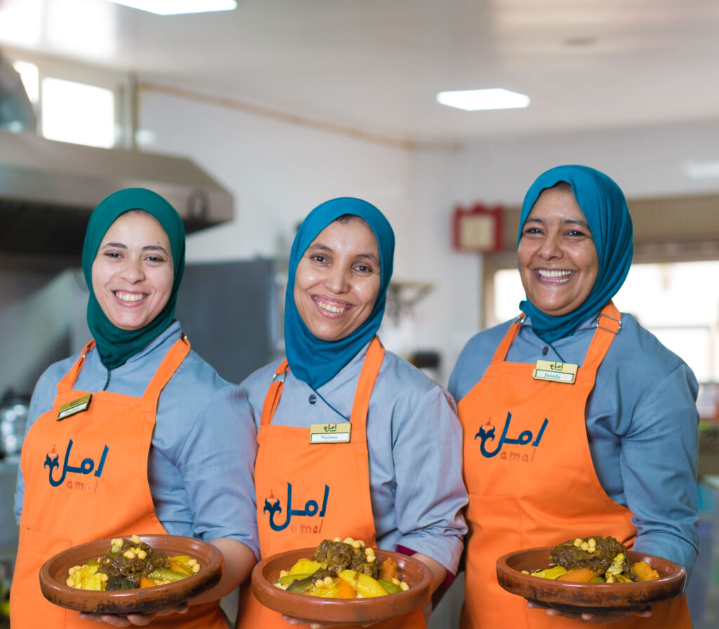 Current Grantees 2 Three women in chef's aprons holding plates of food